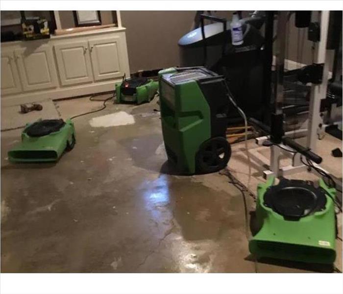 equipment drying damp floor in a basement rec room