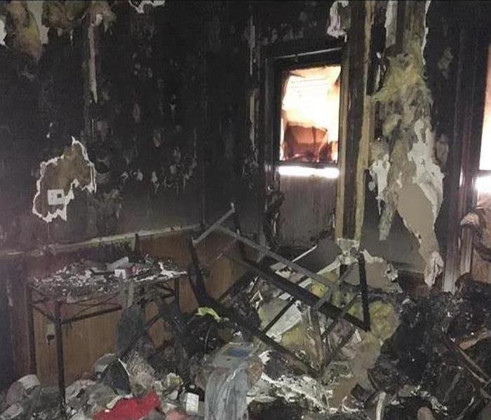 A room destroyed by a fire covered in smoke and soot damage 