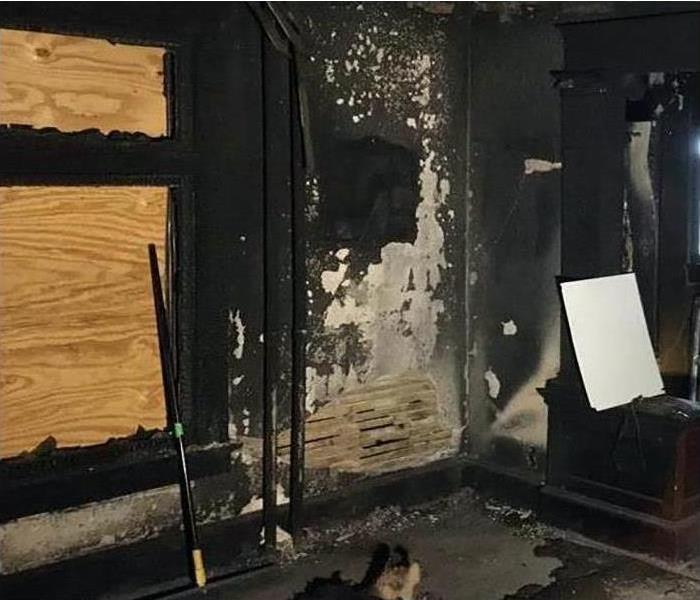 bedroom that is covered in smoke and soot damage from a fire
